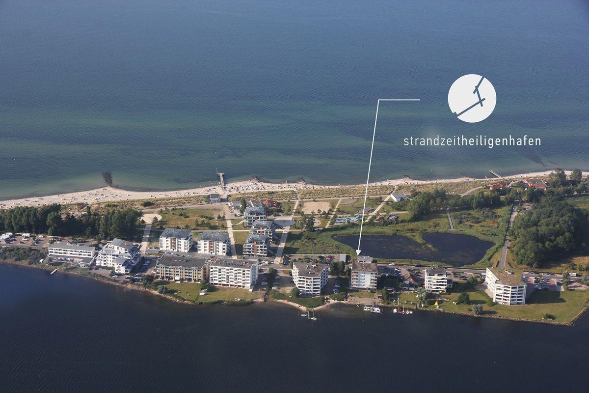 Aerial view of Strandzeitheiligenhafen with beach, buildings, and water.