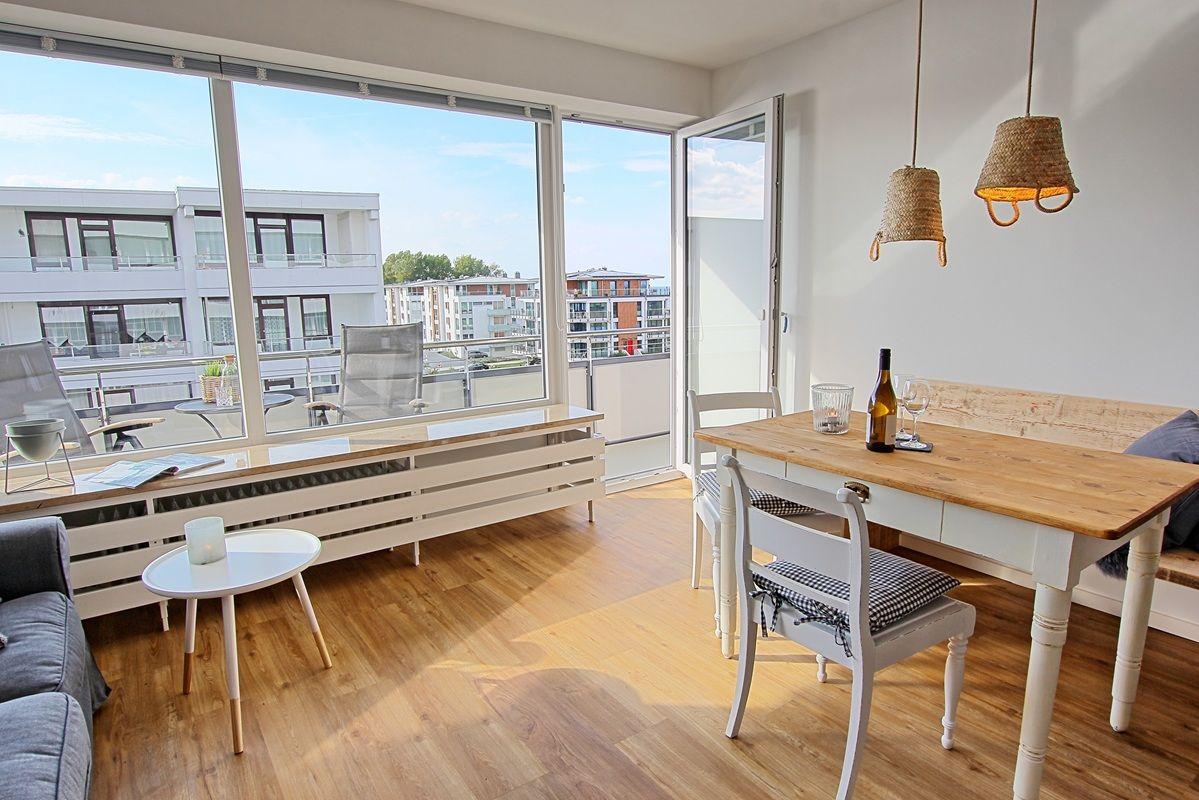 Wohnbereich mit Essbereich, Balkon und großen Fenstern.