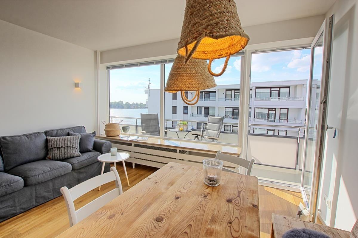 Wohnung mit Essbereich, Sofa und Balkon mit Meerblick.