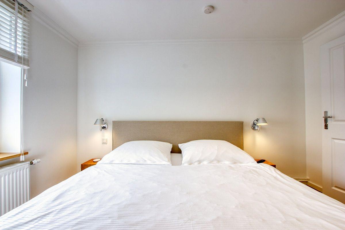 Ein Schlafzimmer mit Doppelbett, zwei Nachttischen und einer Fensterbank.