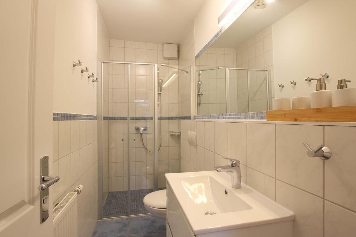 Badezimmer mit Dusche, Waschbecken und Toilette