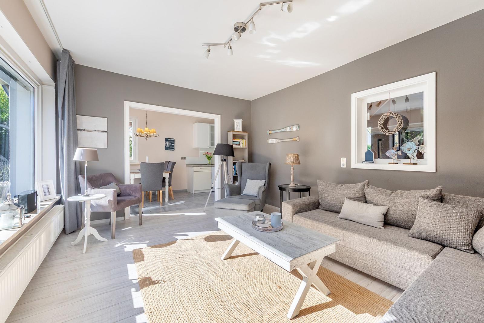 Wohnzimmer mit Sofa, Couchtisch und Blick in die Küche.