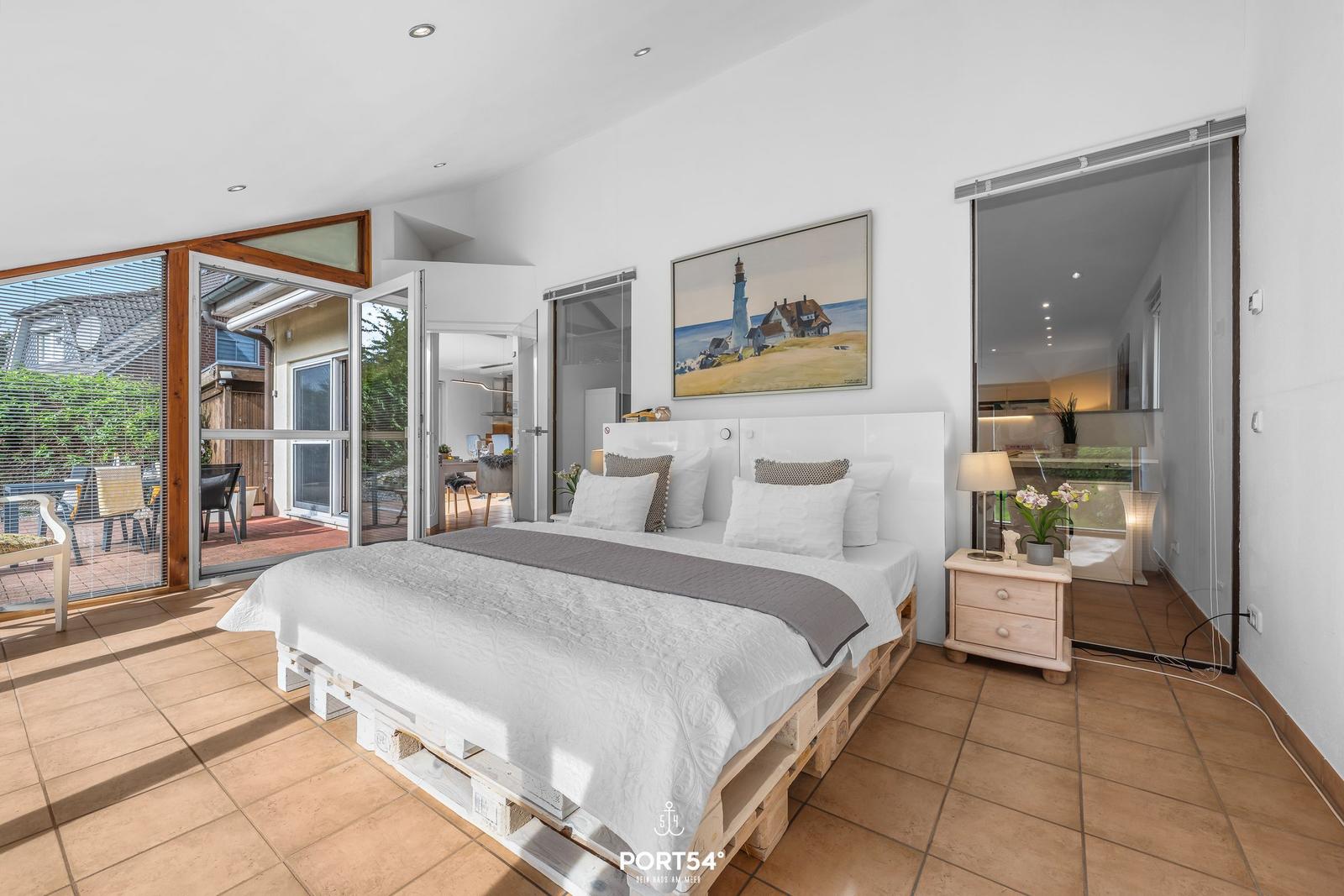 Schlafzimmer mit Bett auf Paletten, Schlafzimmer mit Blick auf Terrasse und Wohnbereich.