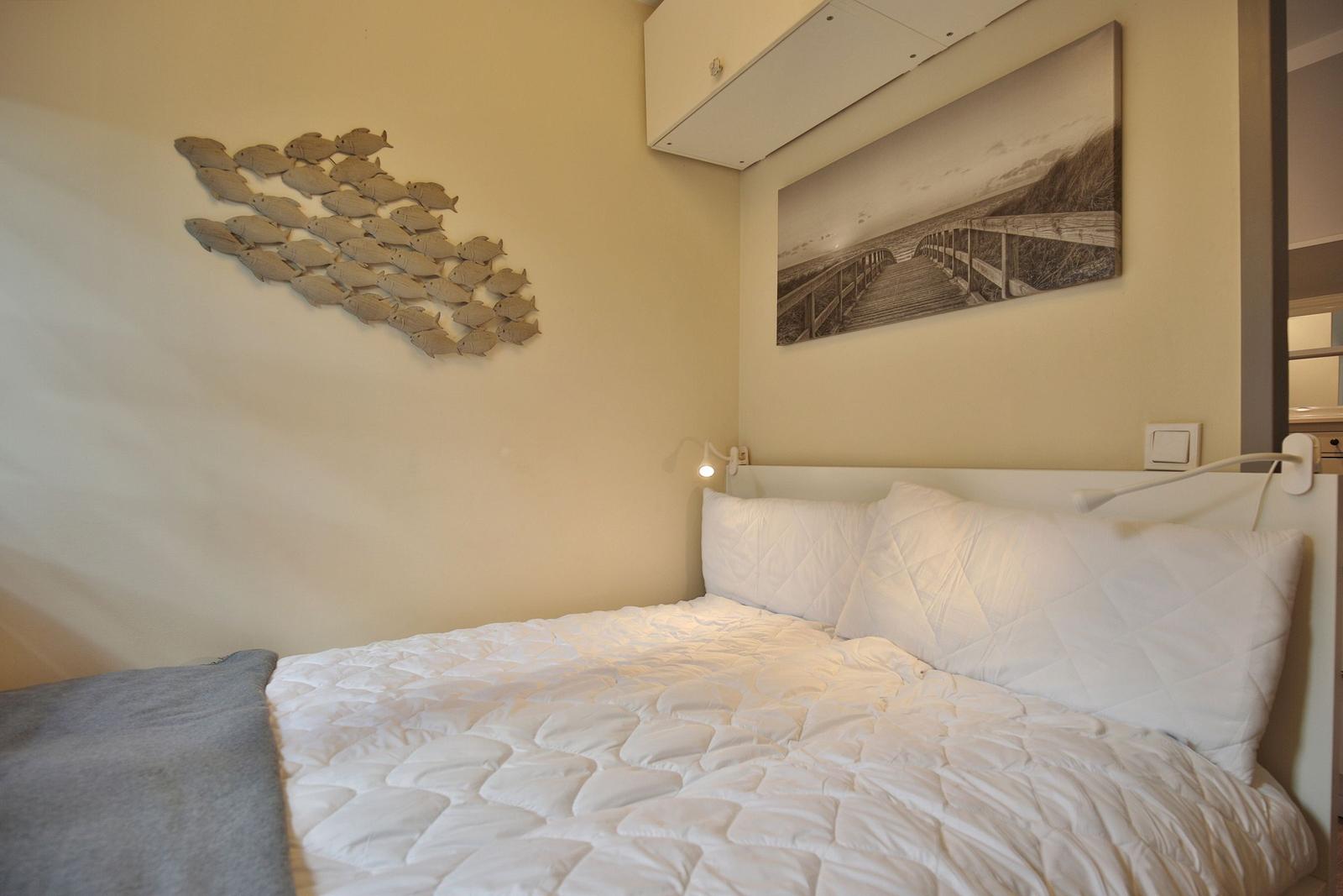 Schlafzimmer mit Bett, Wanddekoration und Wandbild.