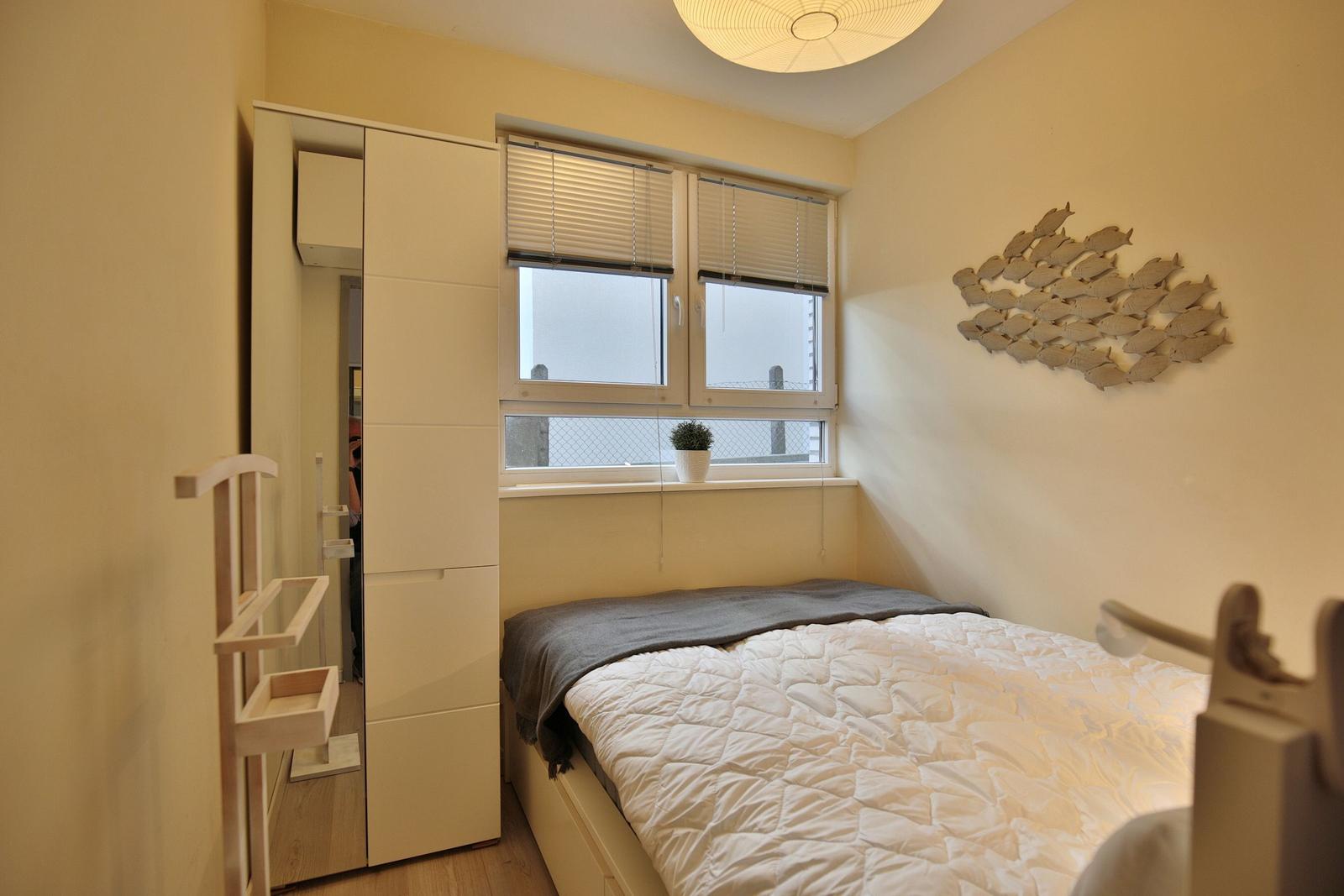 Schlafzimmer mit Bett, Fenster und Wanddekoration