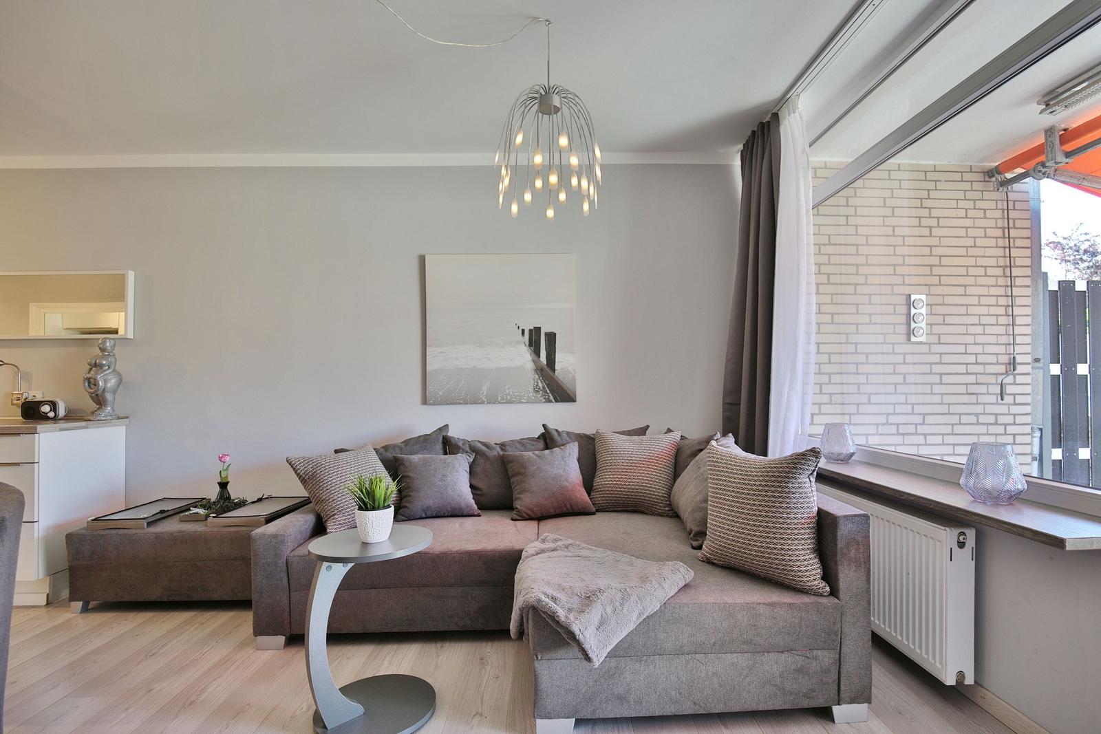 Wohnzimmer mit Sofa, Beistelltisch und moderner Deckenleuchte.