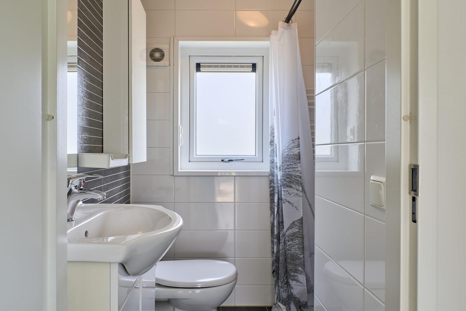 Badezimmer mit Waschbecken, Toilette und Duschvorhang
