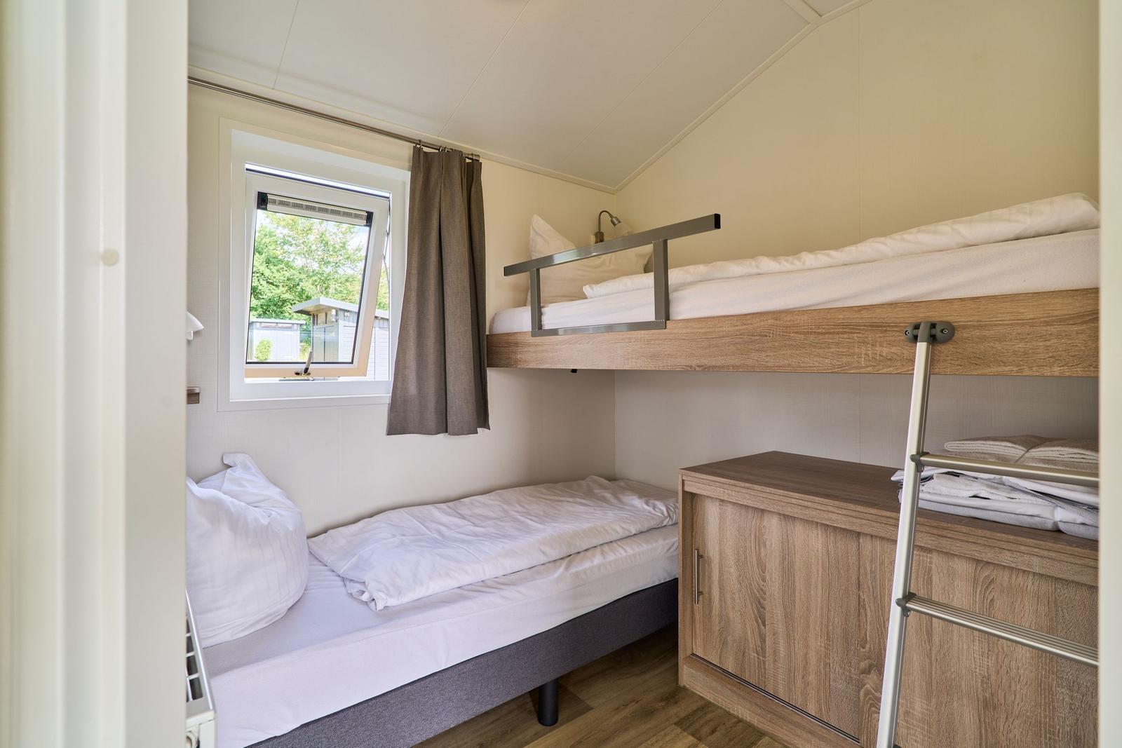 Zimmer mit zwei Betten, einem Schrank und einem Fenster.