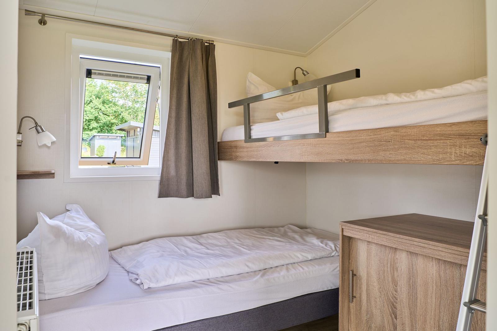 Zimmer mit Hochbett, Fenster und Schrank
