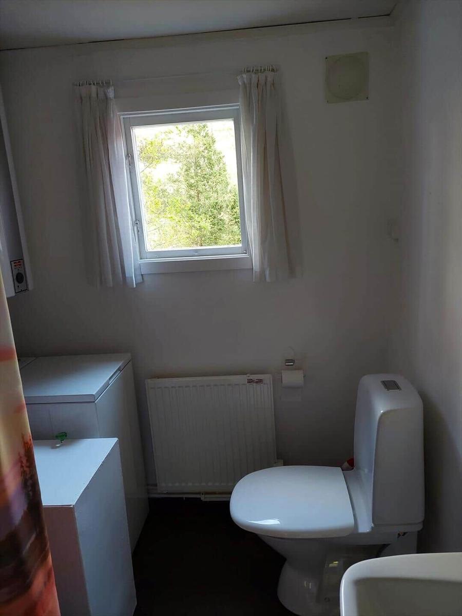 Badezimmer mit Toilette, Fenster und Heizkörper