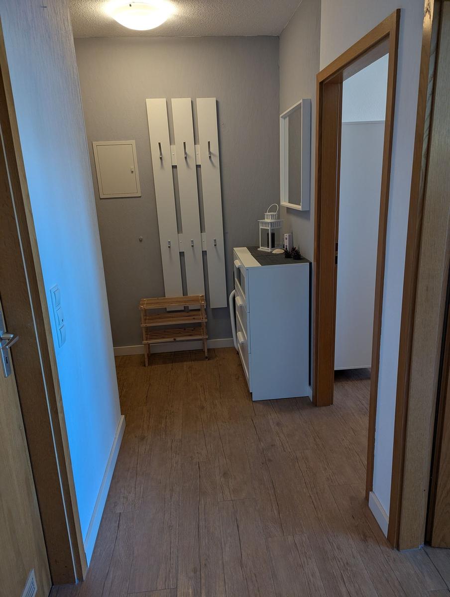 Flur mit Garderobe, Schuhschrank und Spiegel an der Wand.