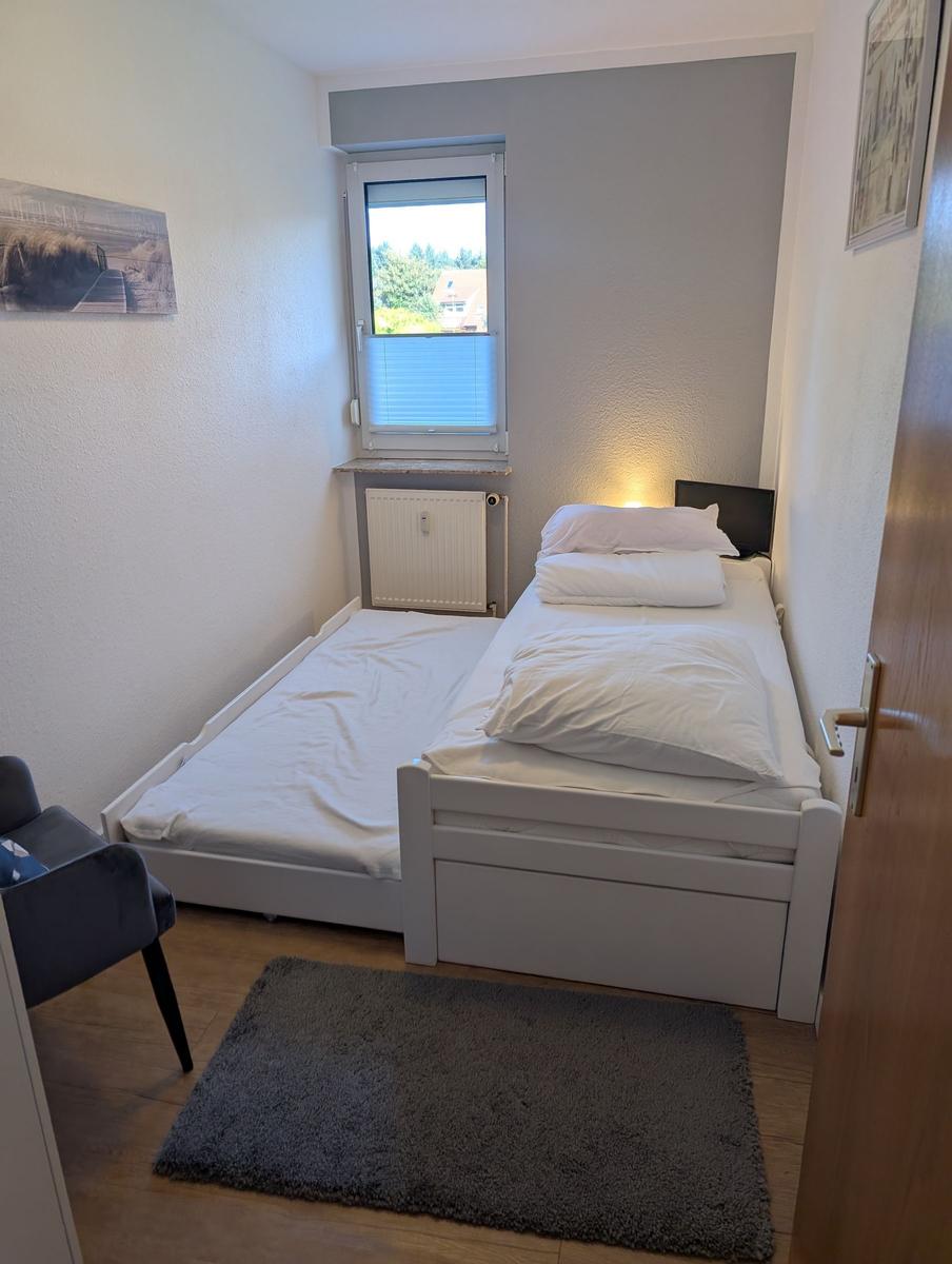 Ein Schlafzimmer mit einem Bett, einem Fenster und einem Teppich.