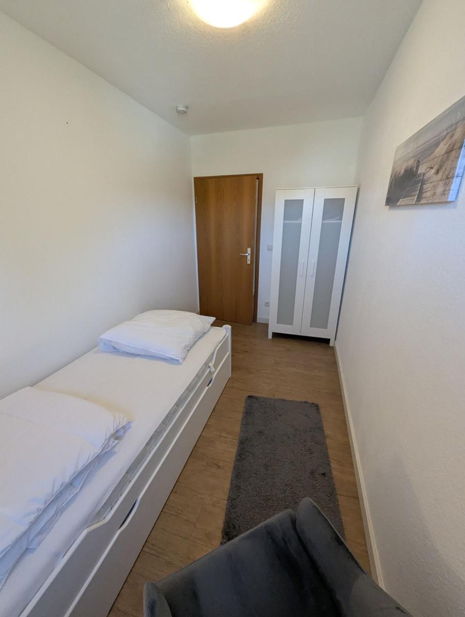 Schlafzimmer mit Bett, Kleiderschrank und Teppich