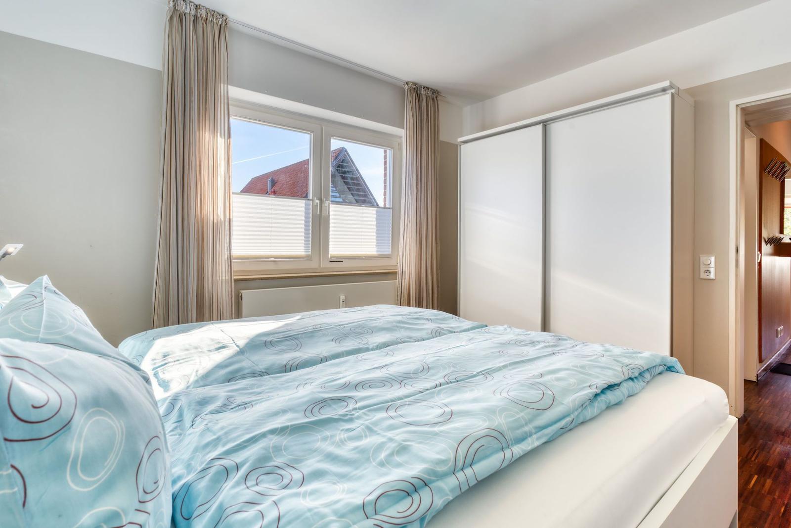 Schlafzimmer mit Doppelbett, Fenster und Schrank
