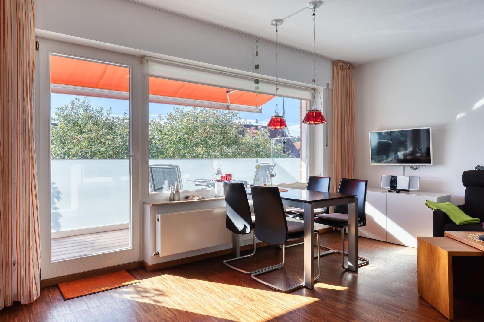 Esszimmer mit Balkon, TV und moderner Beleuchtung.