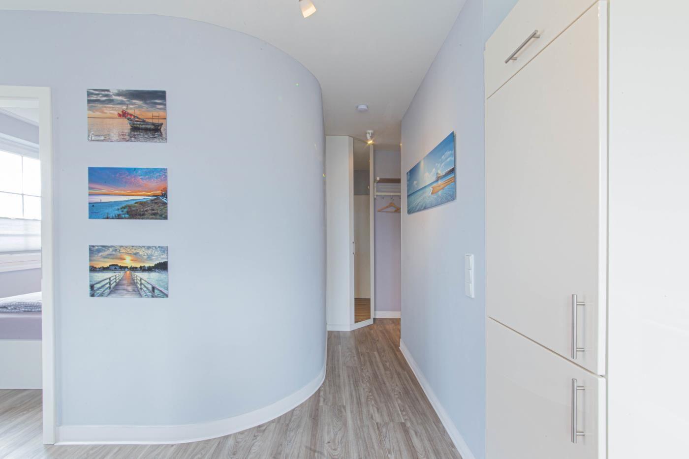 Flur mit Licht, Wandbildern und Schränken