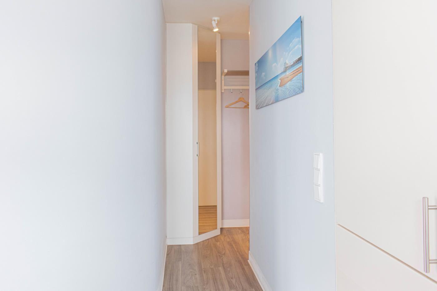 Flur mit Kleiderschrank und Wandbild an der Wand.