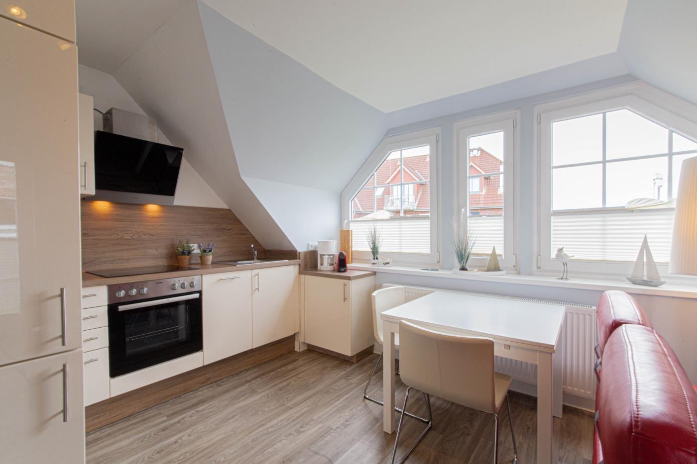 Küche mit Essbereich unter Dachschräge, Fenster mit Blick auf Dächer.