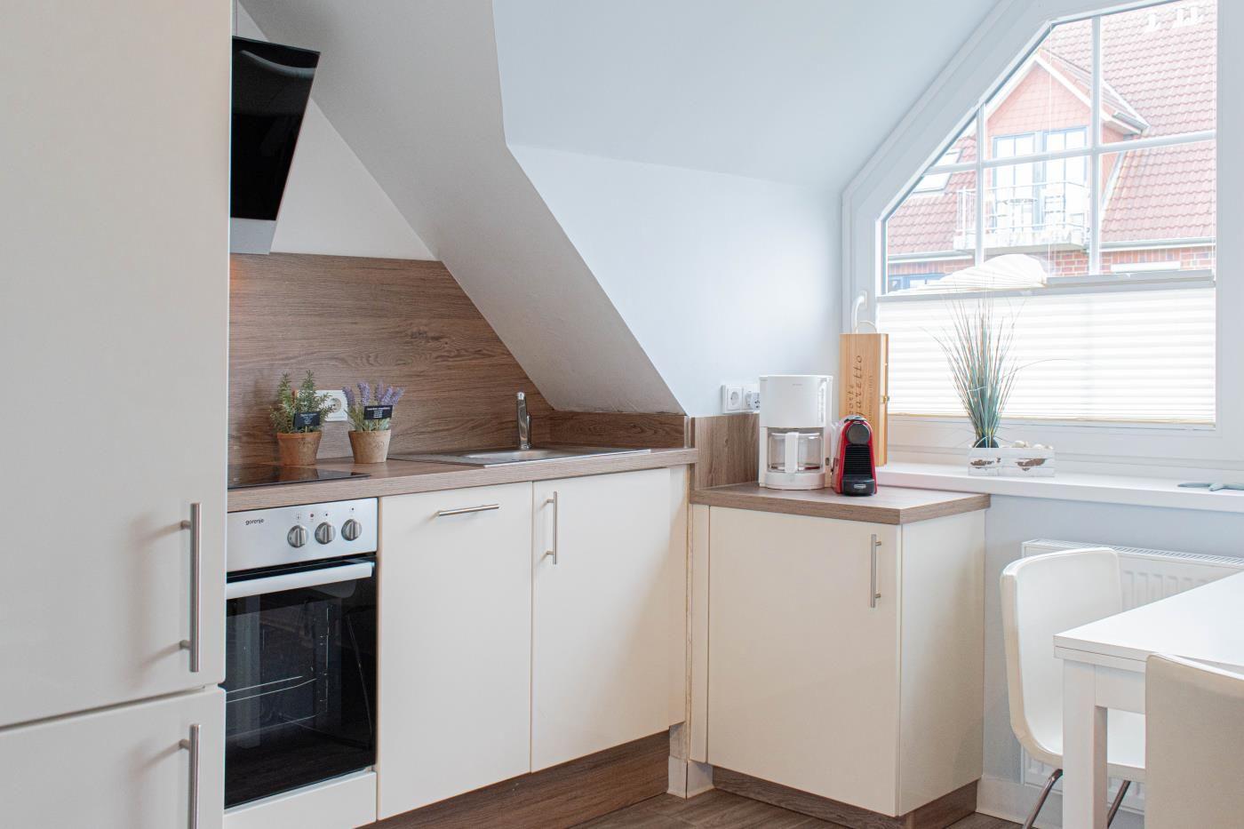 Küche mit Arbeitsplatte, Spüle, Herd und Fenster mit Blick.