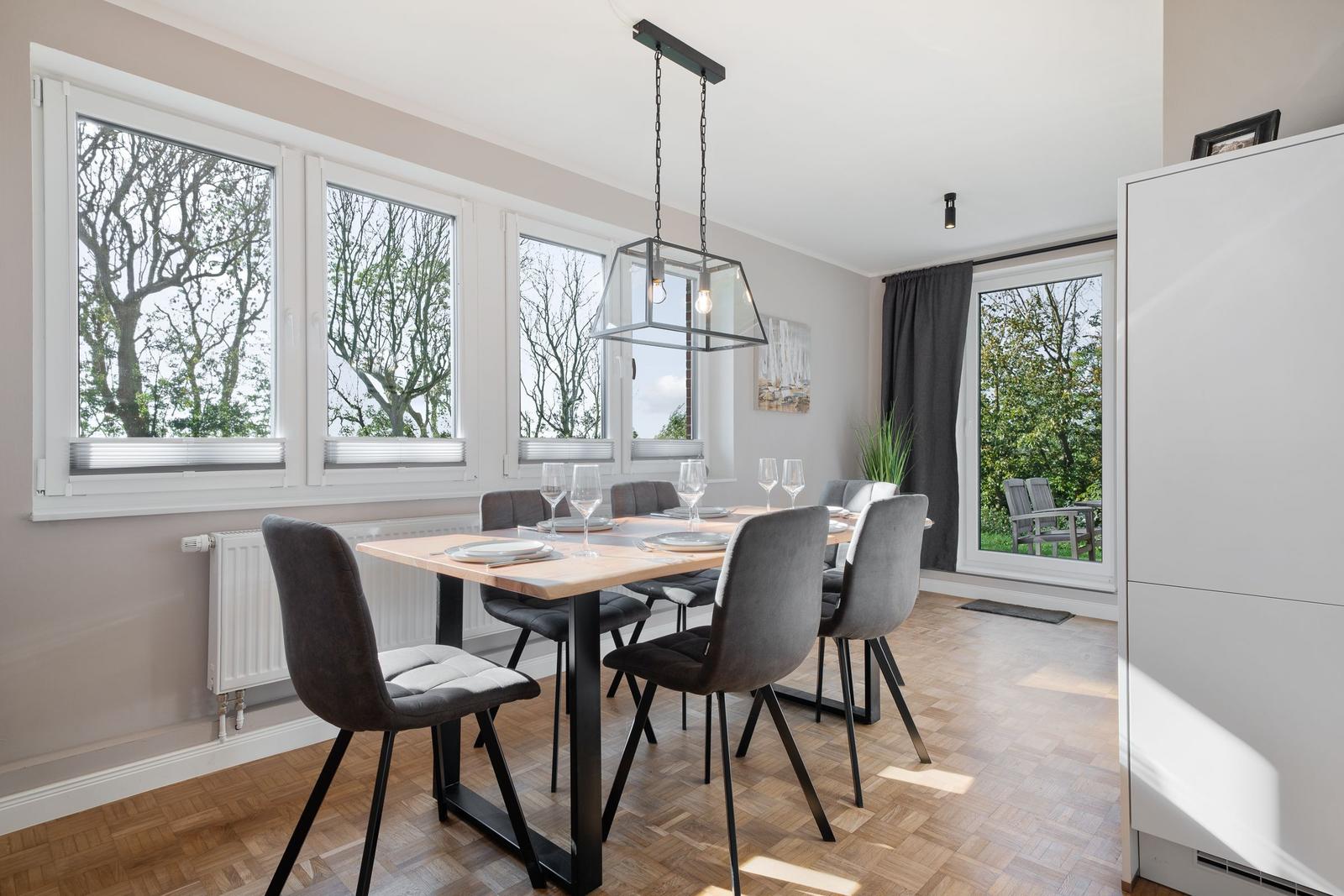 Dining room with table, chairs, and windows to the garden.