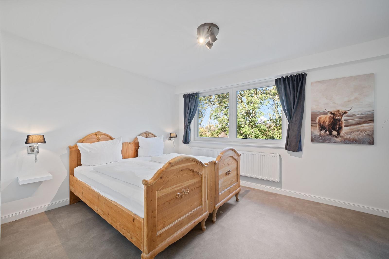 Bedroom with wooden bed, window, and wall picture.