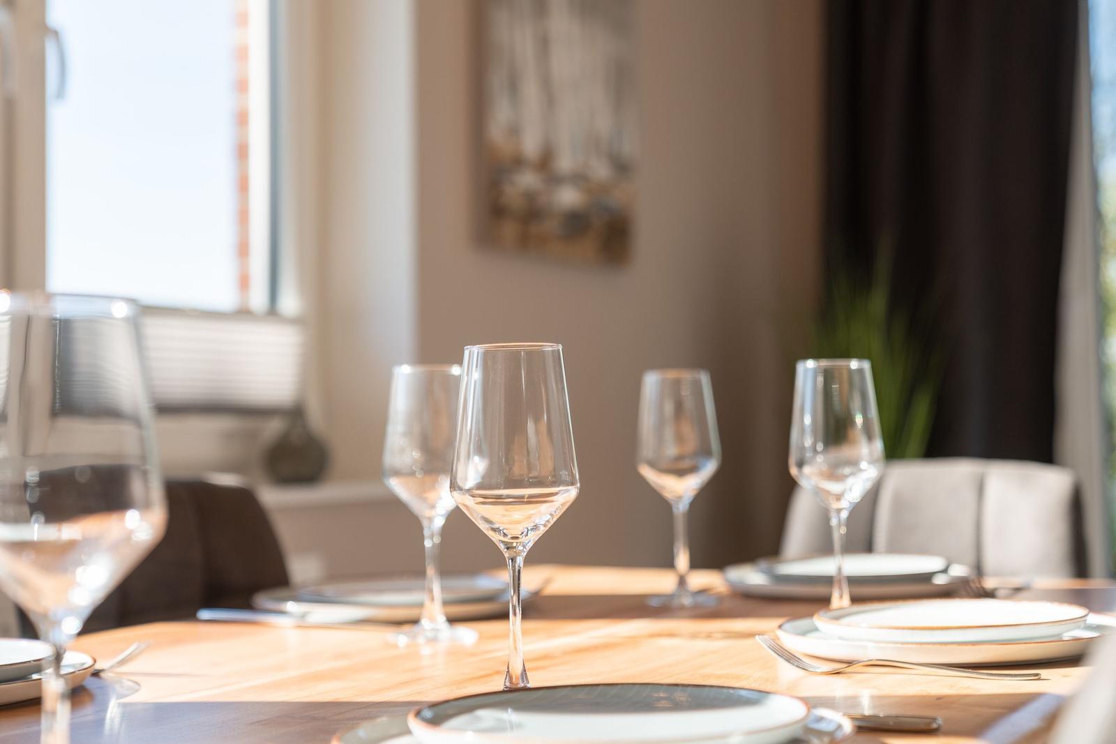 Dining table with glasses and plates in dining room