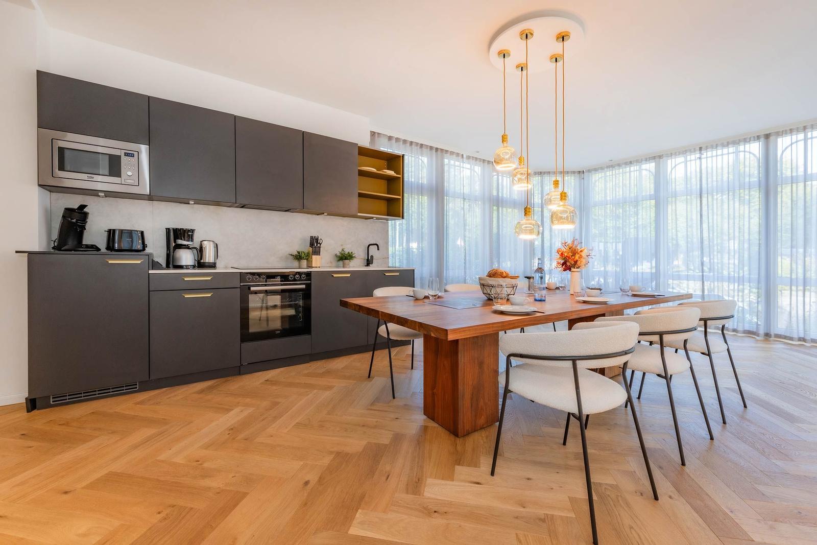 Küche mit Essbereich, Holzboden und großem Fenster