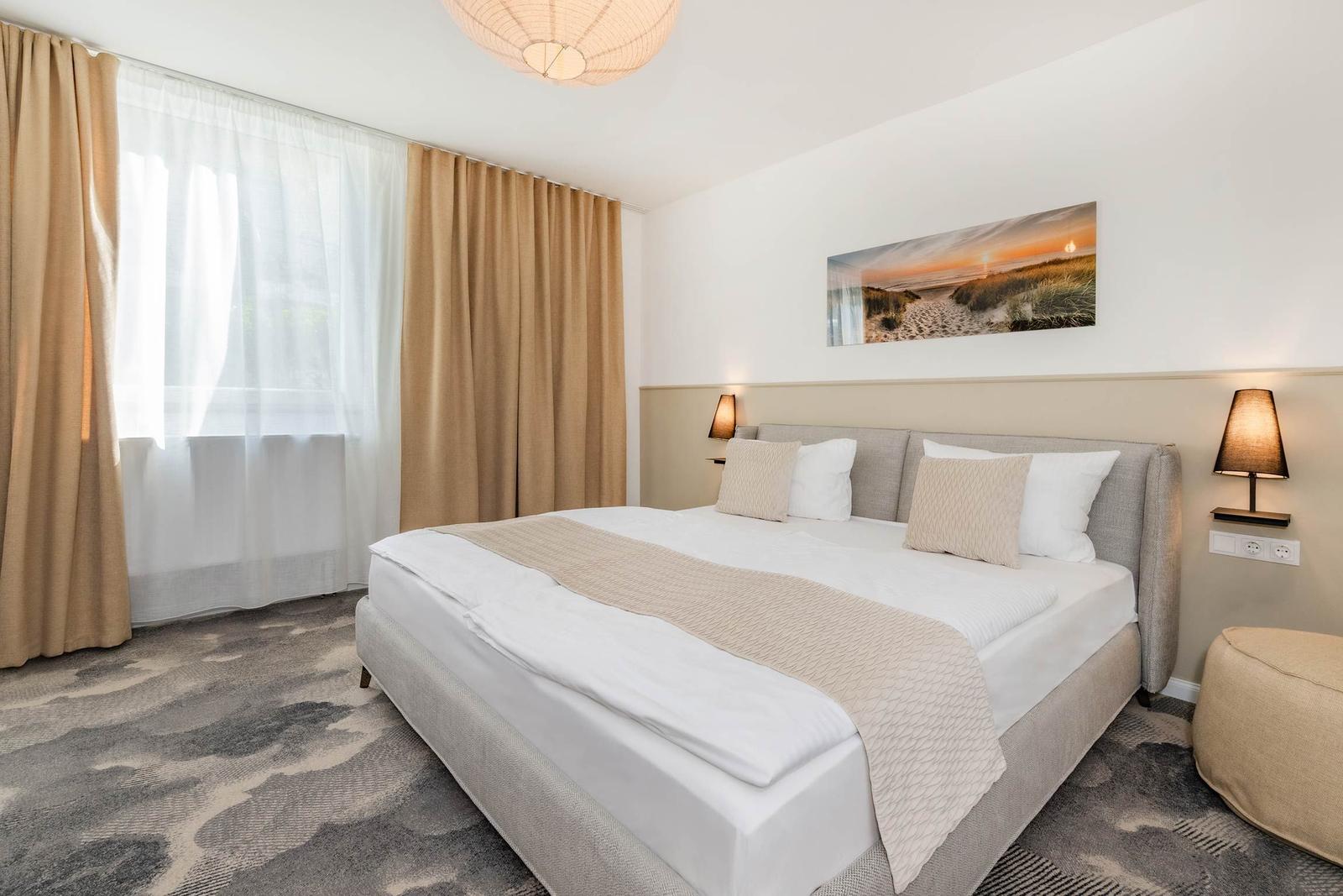 Schlafzimmer mit großem Bett, Vorhängen und Wandbild.