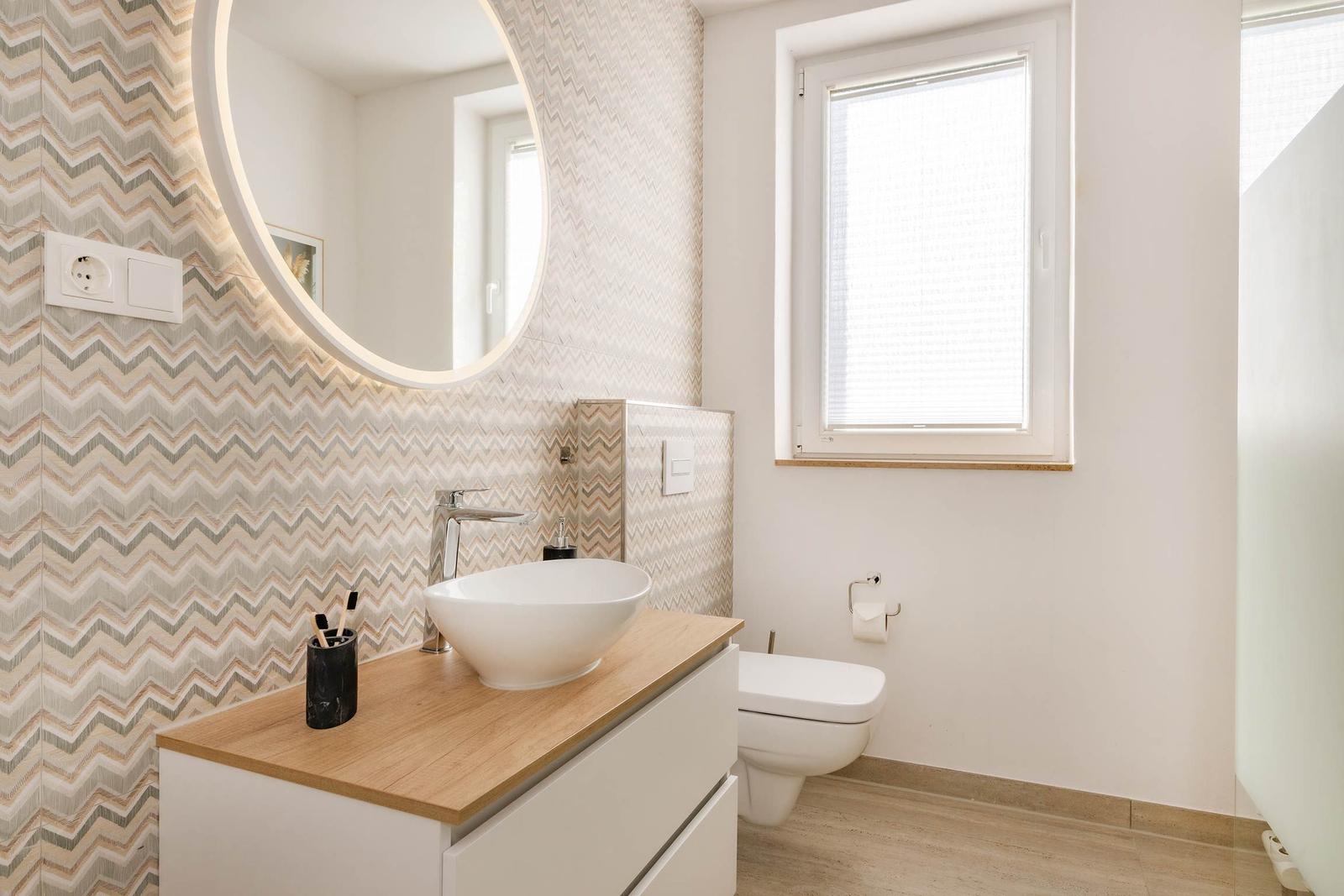 Badezimmer mit Waschtisch, Spiegel und Toilette