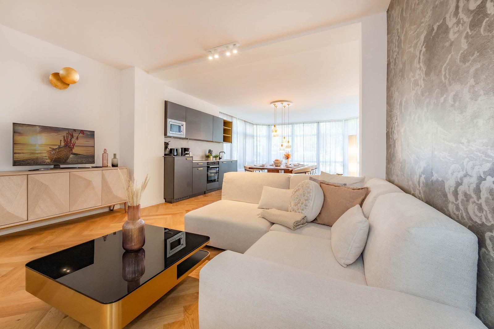 Wohn- und Essbereich mit moderner Küche und großem Sofa.