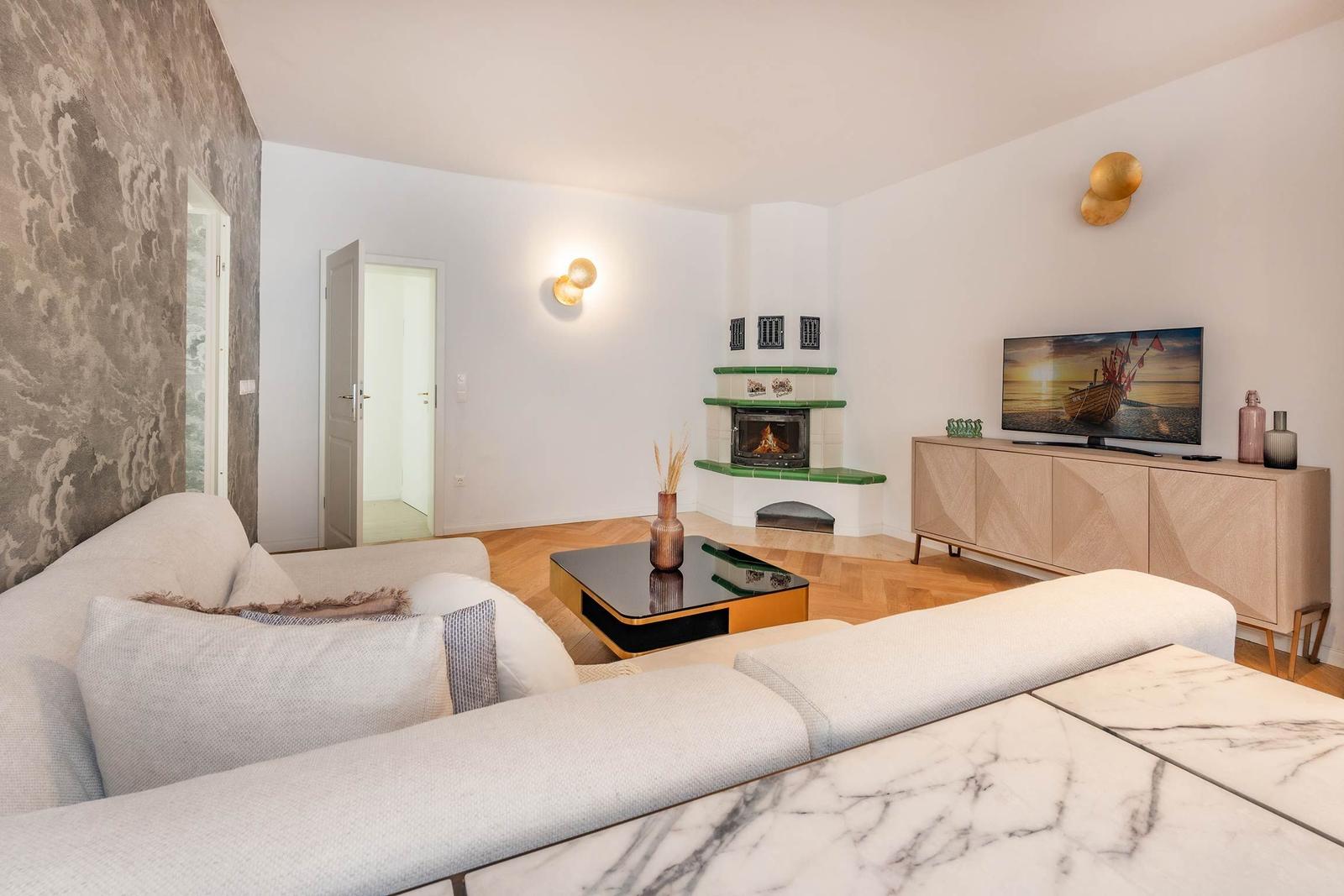 Wohnzimmer mit Sofa, Kamin und Fernseher.