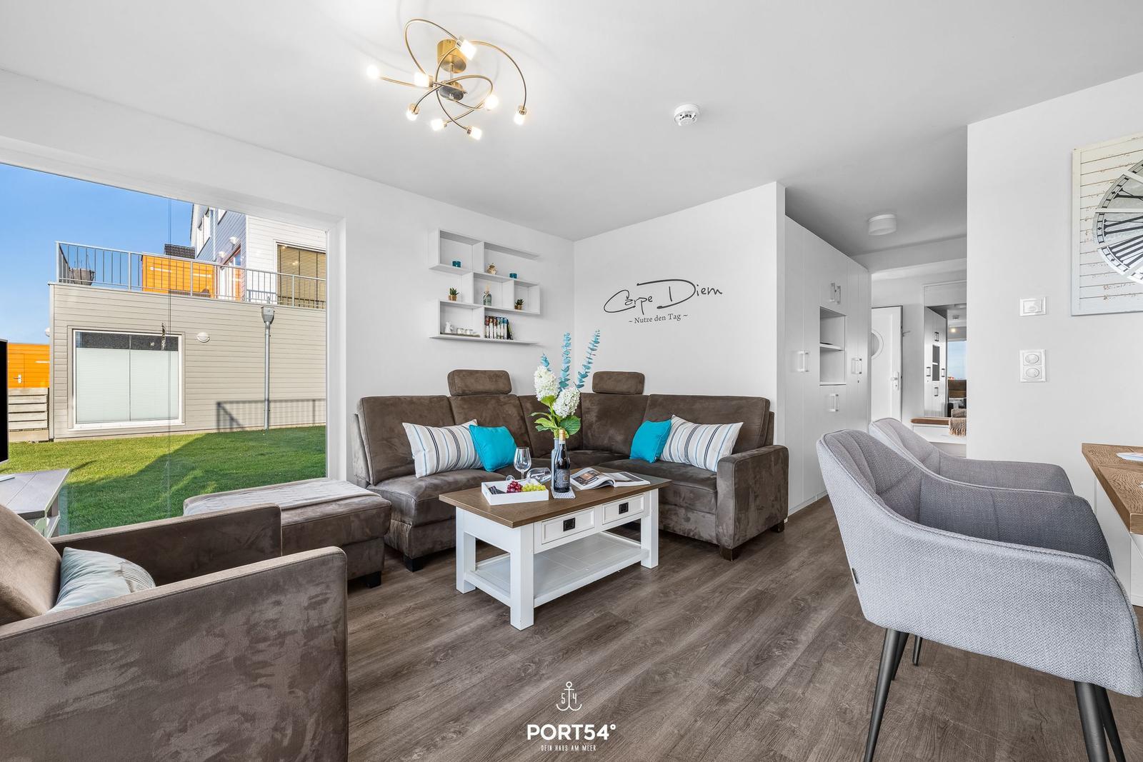 Wohnzimmer mit Sofa, Couchtisch und Blick auf die Terrasse.