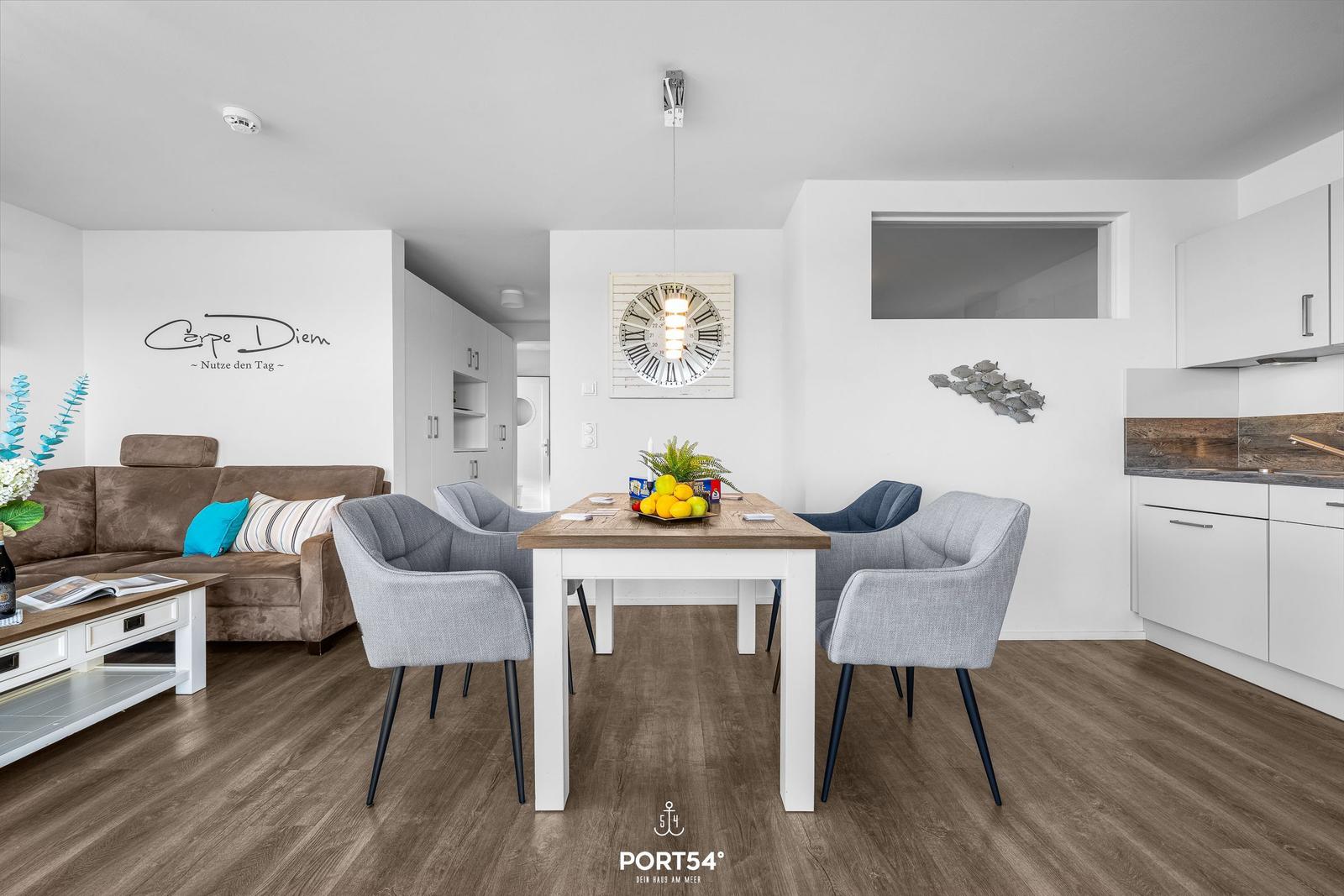 Wohn- und Essbereich mit Sofa, Esstisch und Küche.