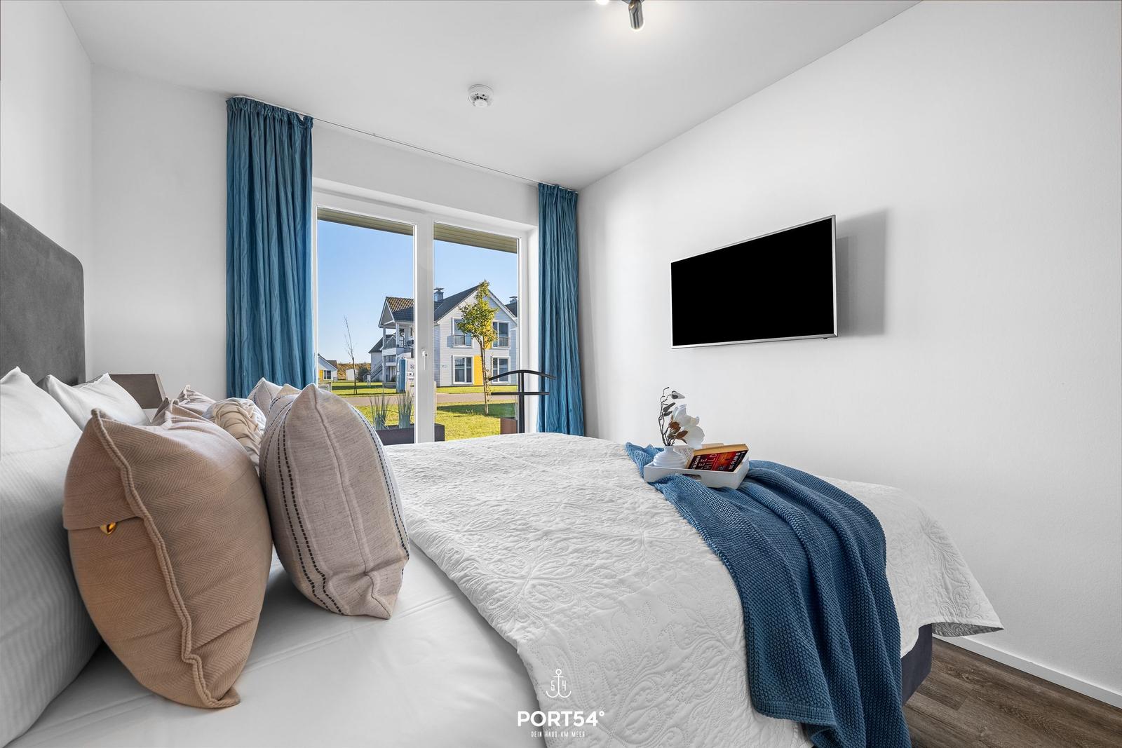 Schlafzimmer mit Bett, TV und Blick auf Garten