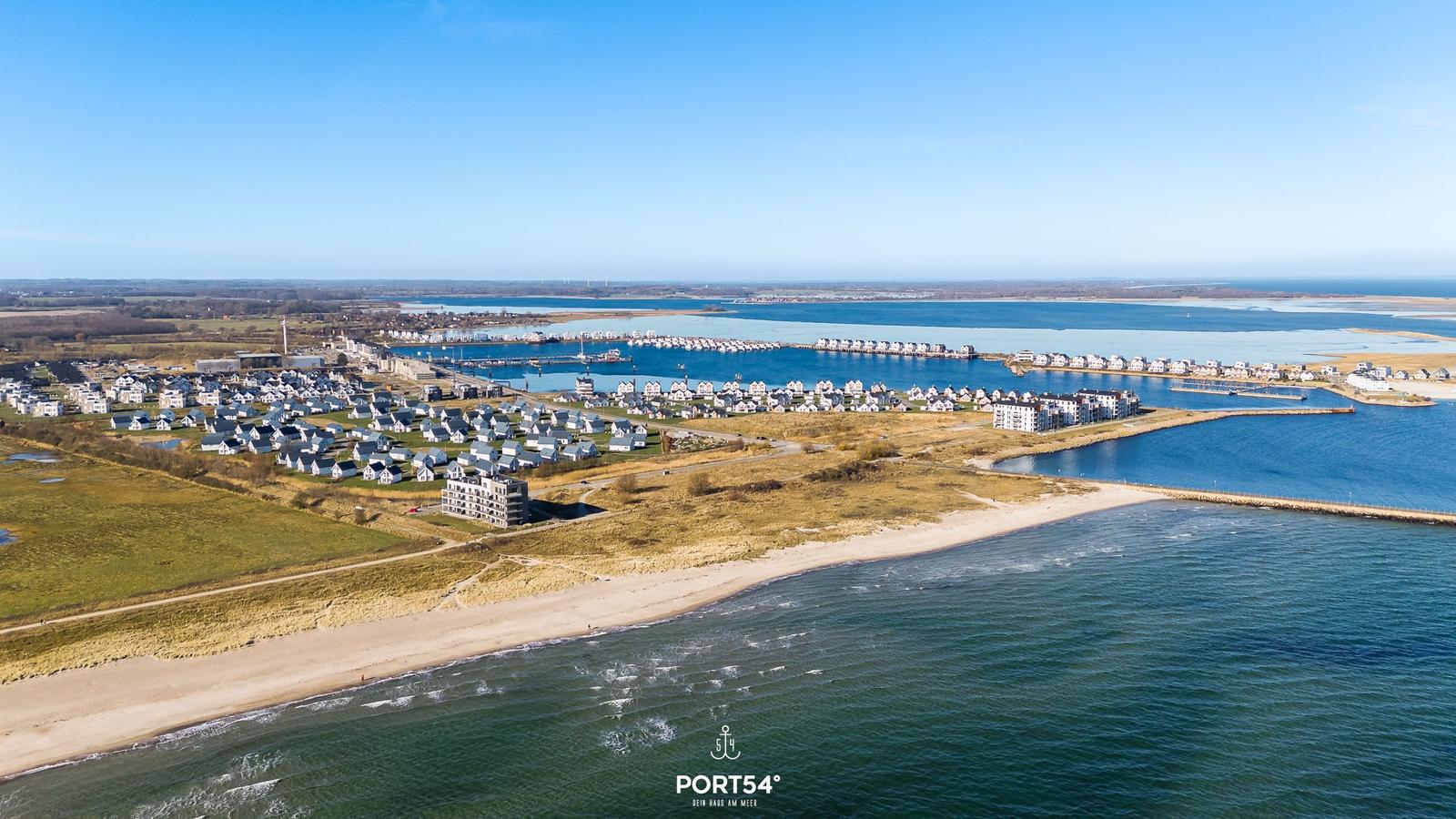 Ausblick auf Küstenort mit Häusern, Hafen und Meer