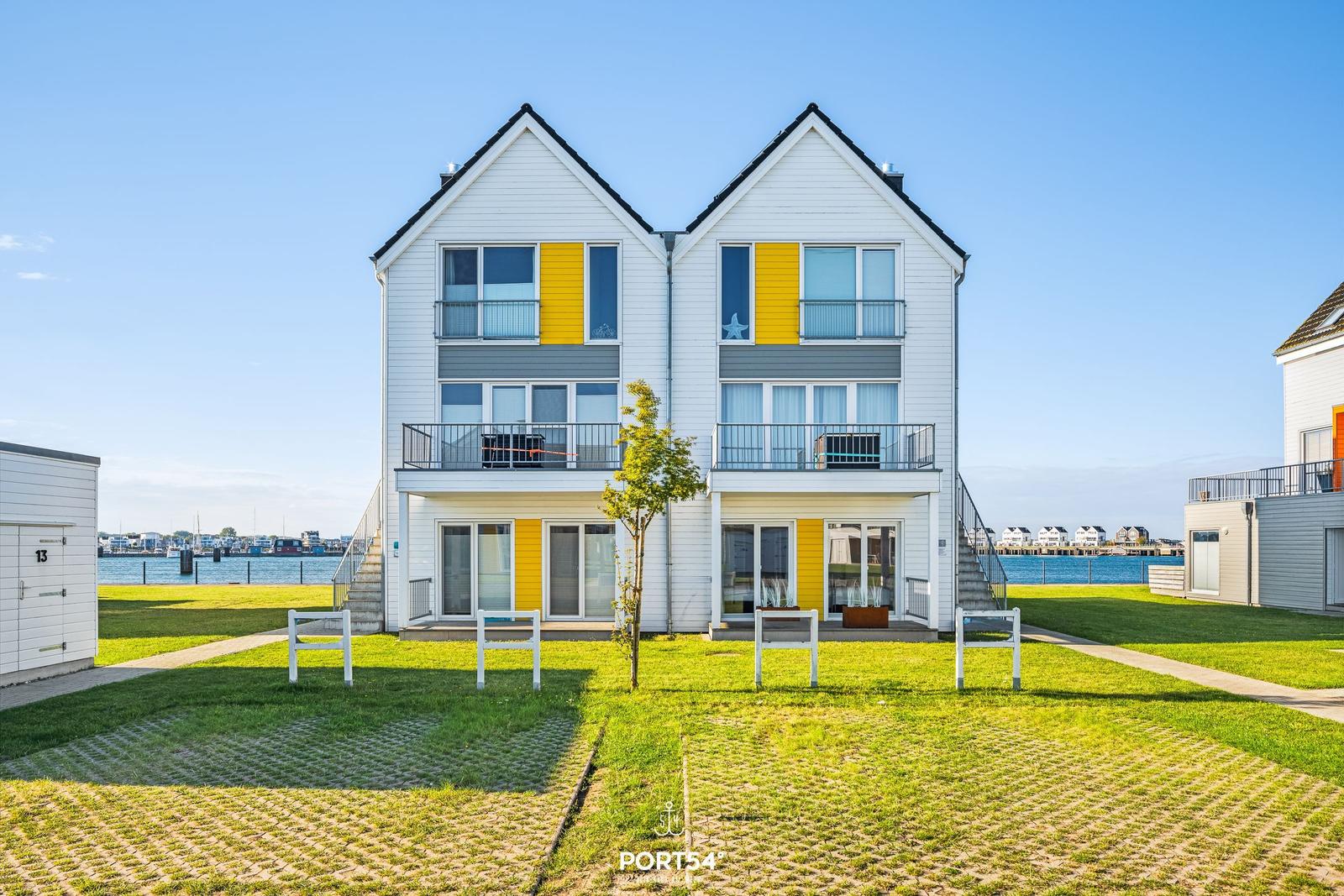 Zweistöckiges Haus mit Balkonen und Blick auf Wasser