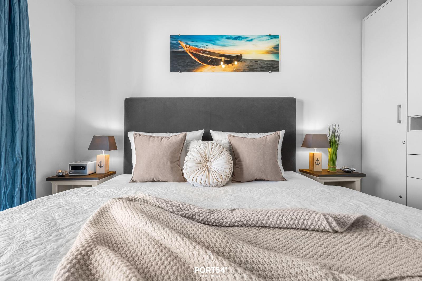 Schlafzimmer mit Bett, Nachttischen und Wandbild