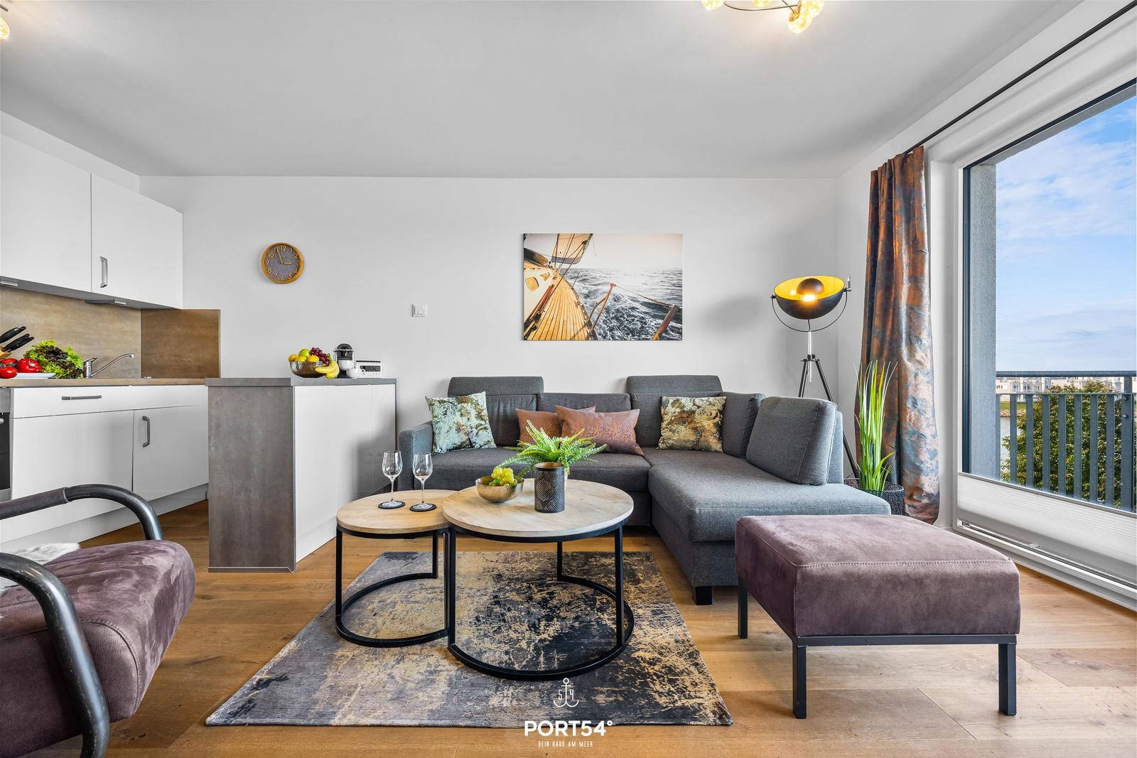 Wohnung mit Essbereich, Sofa, Couchtisch und Blick auf Balkon.