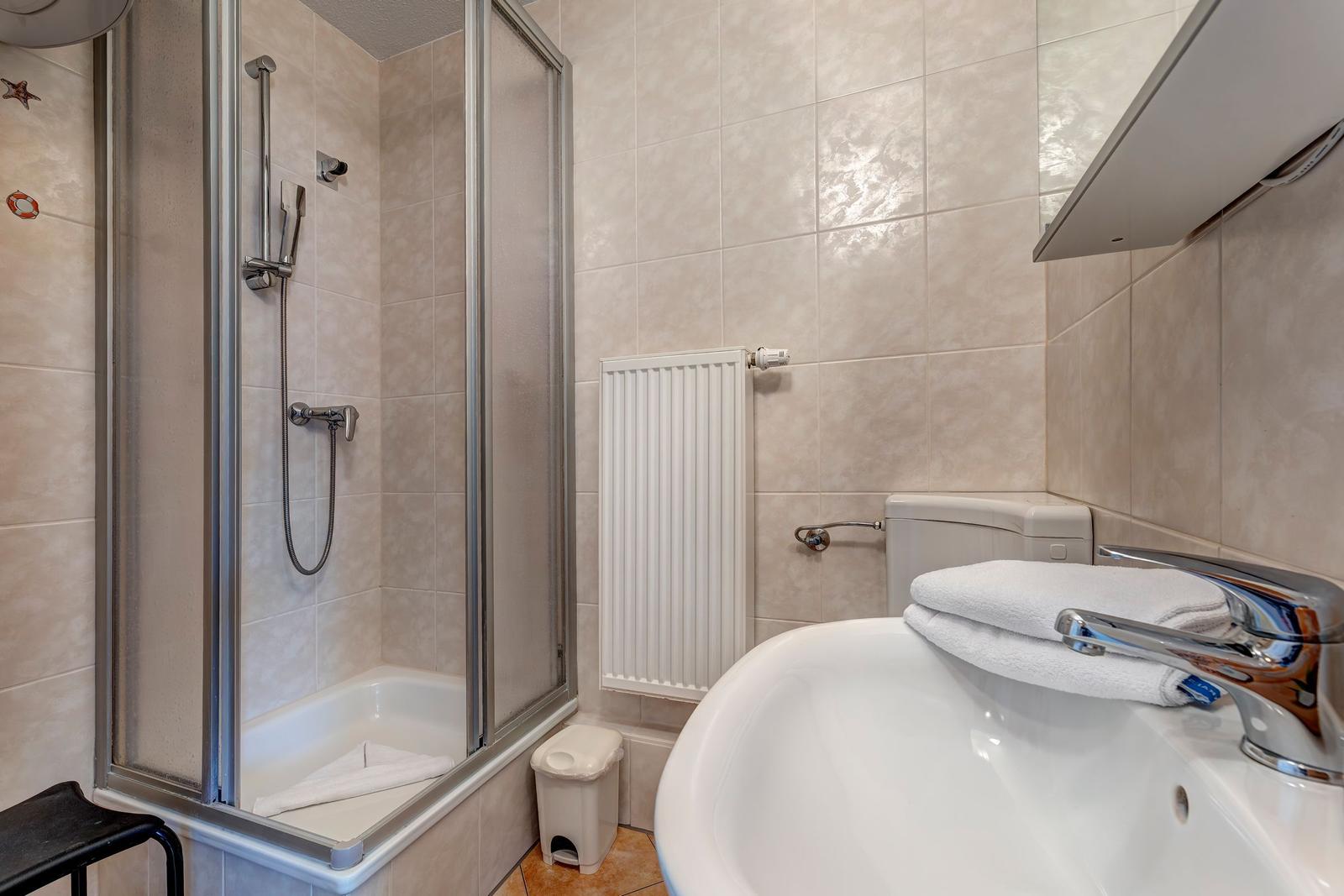 Bad mit Dusche, Badewanne und Waschbecken.