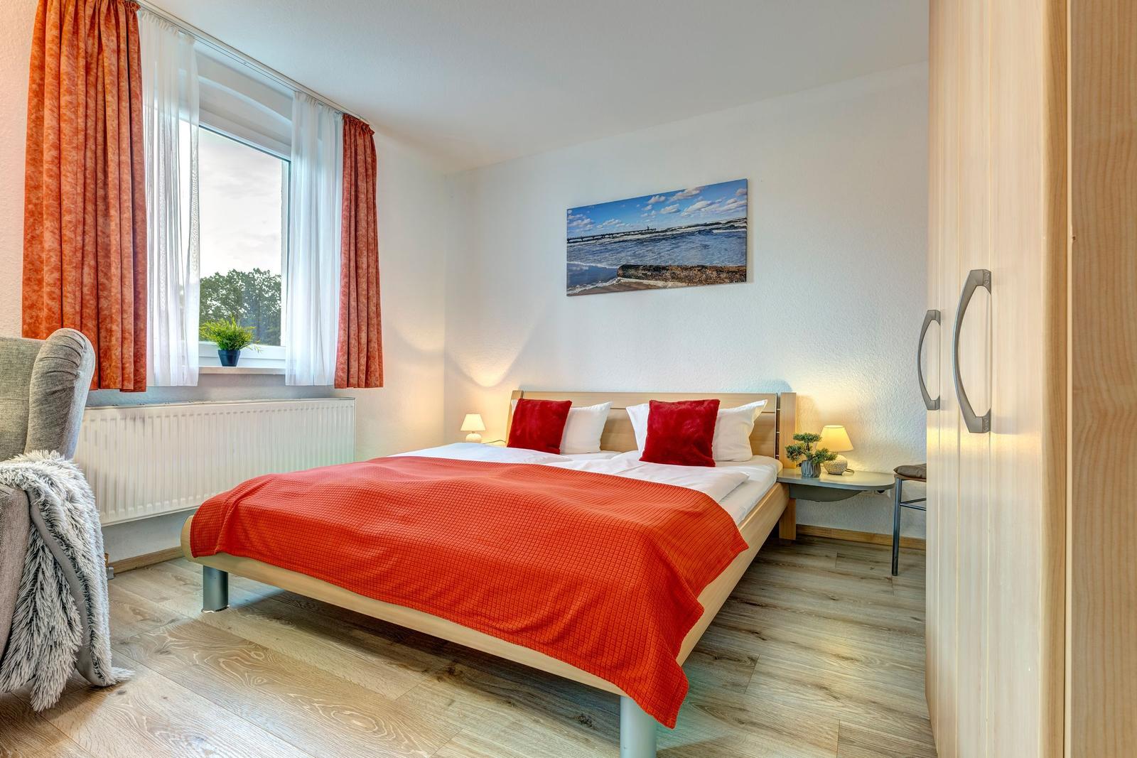 Schlafzimmer mit Bett, Fenster und Kleiderschrank