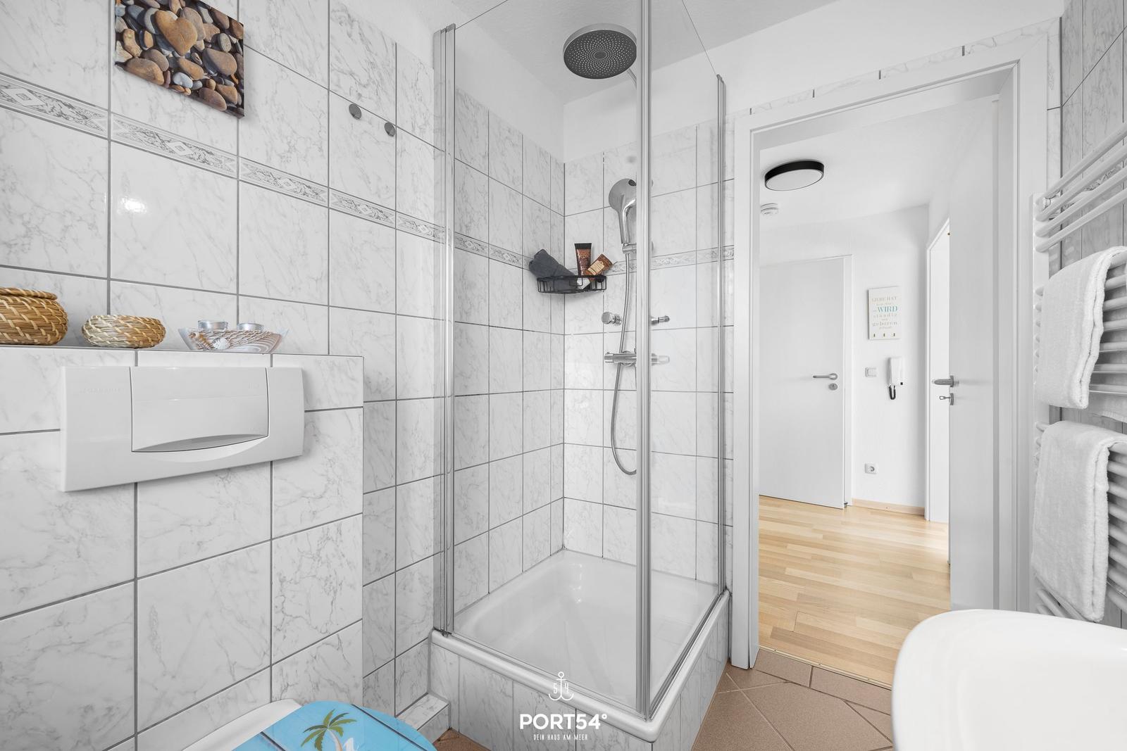 Badezimmer mit Dusche, Handtuchheizung und Toilette