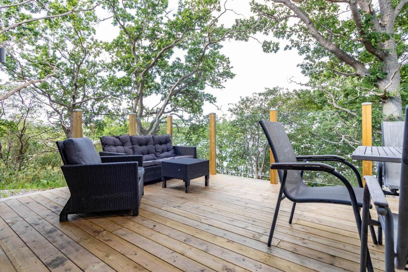 Terrasse mit Sitzgruppe und Tisch unter Bäumen