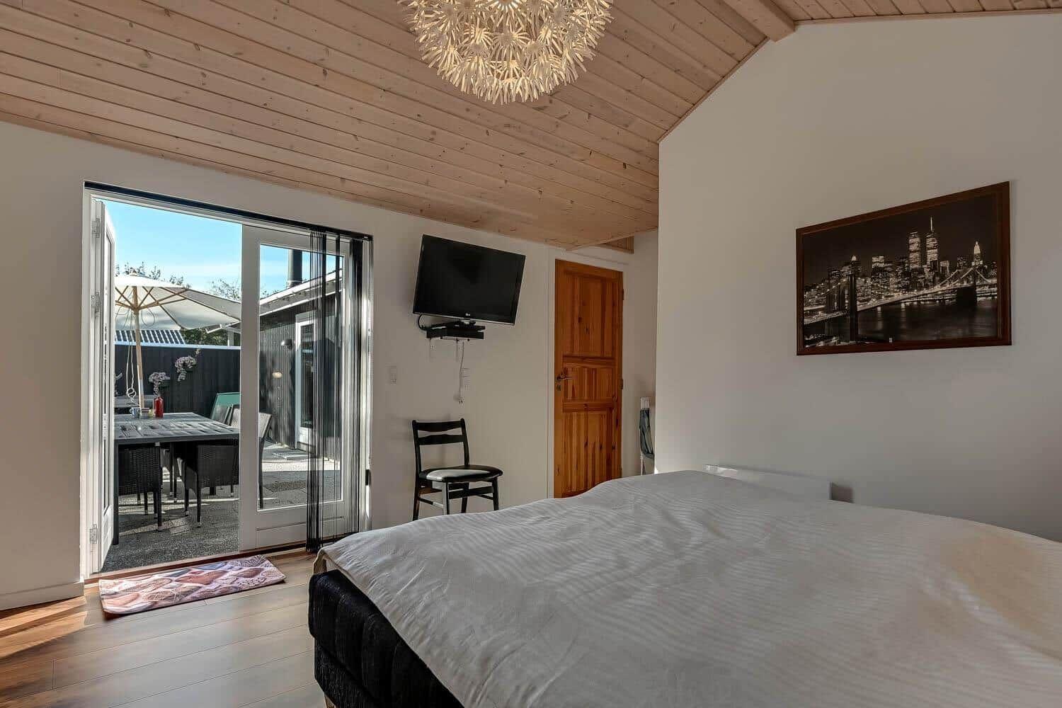Bedroom with bed, TV, and access to the garden.