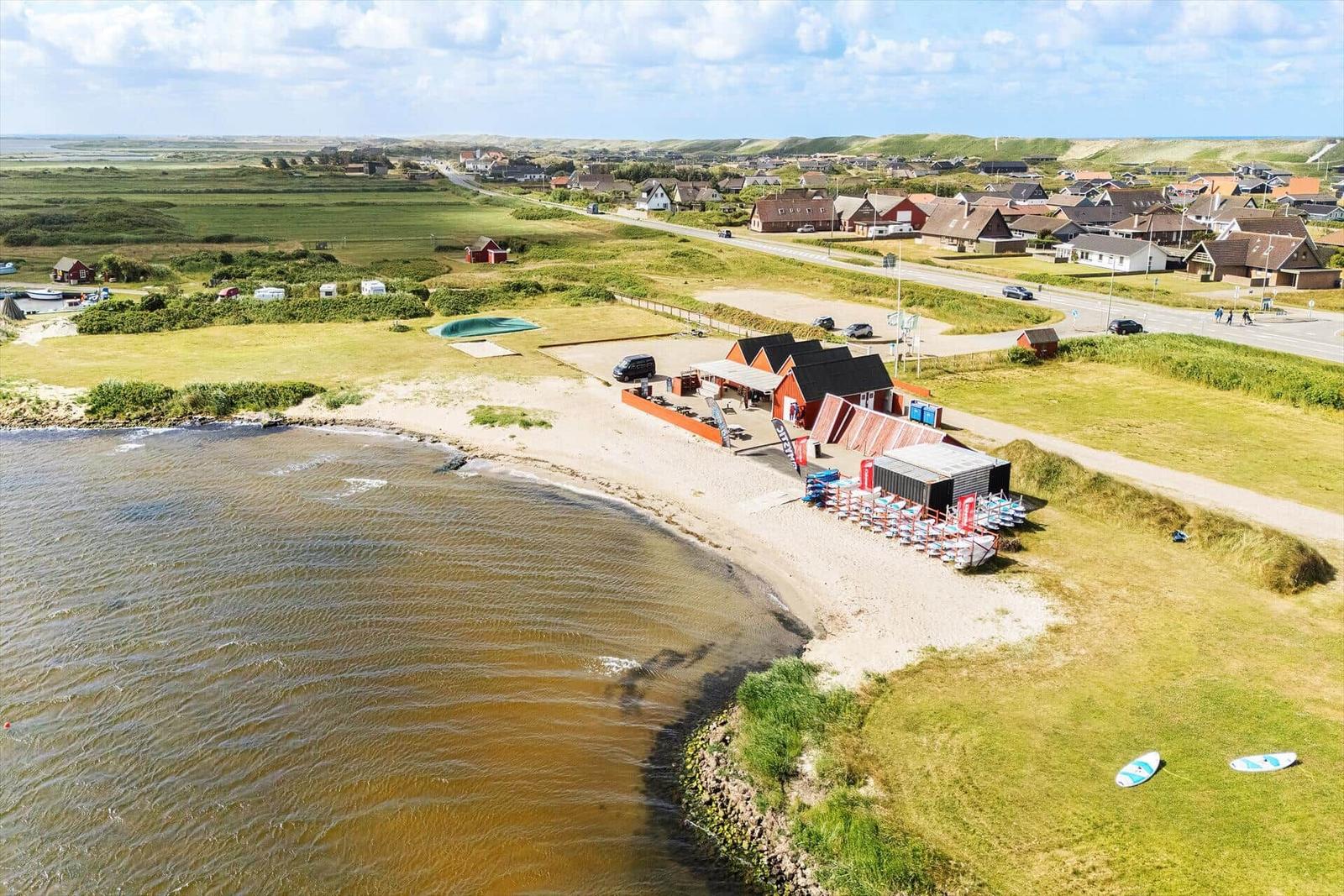 Strand mit Bootssteg, Strandkörben und Ferienhäusern am Ufer