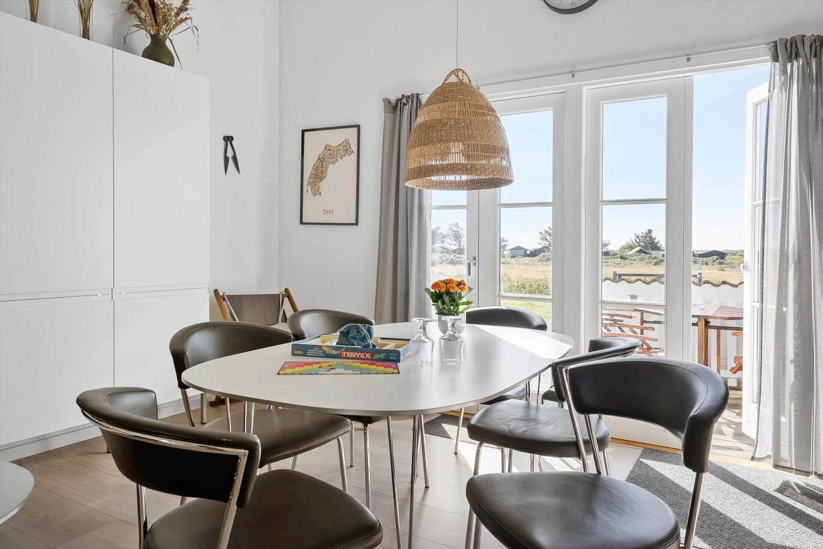 Esszimmer mit Tisch, Stühlen und Blick auf Balkon