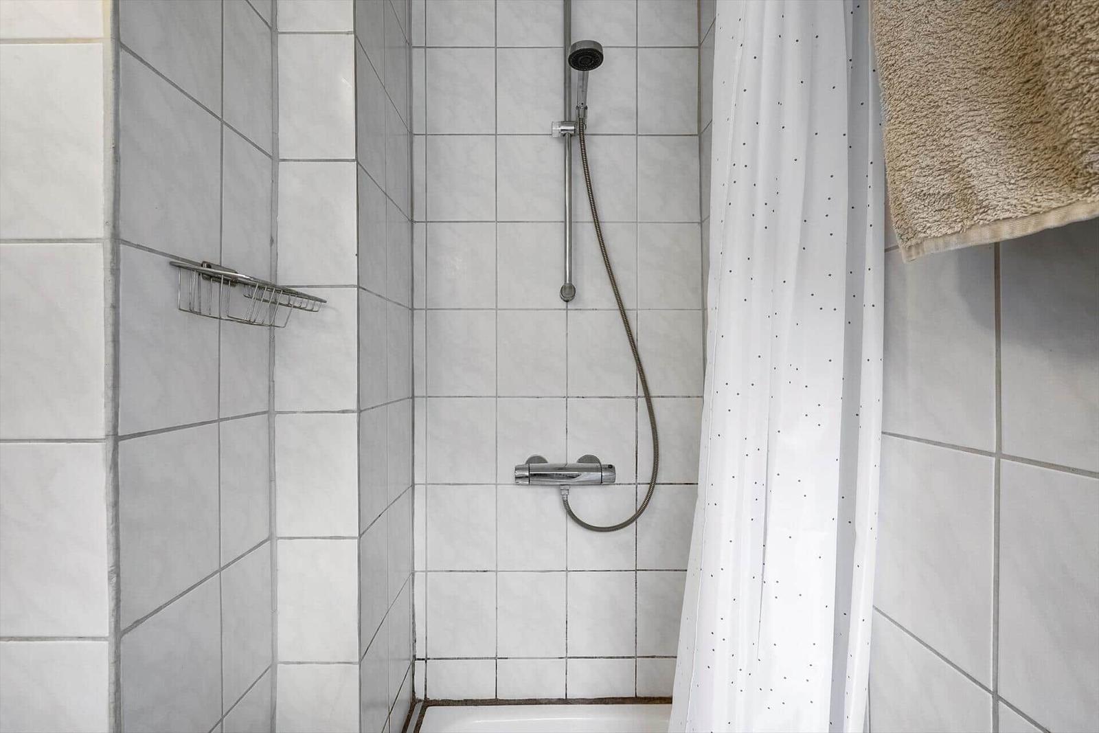 Dusche mit Duschbrause und Duschvorhang