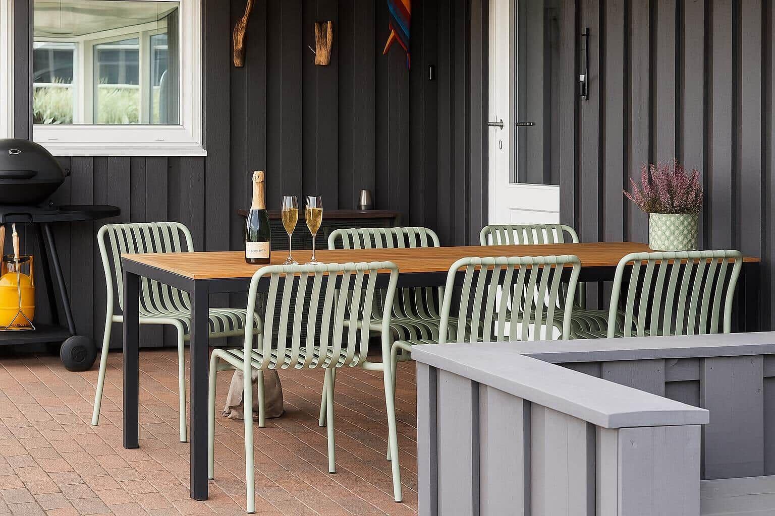Terrasse mit Tisch, Stühlen, Grill und Blumenpflanze