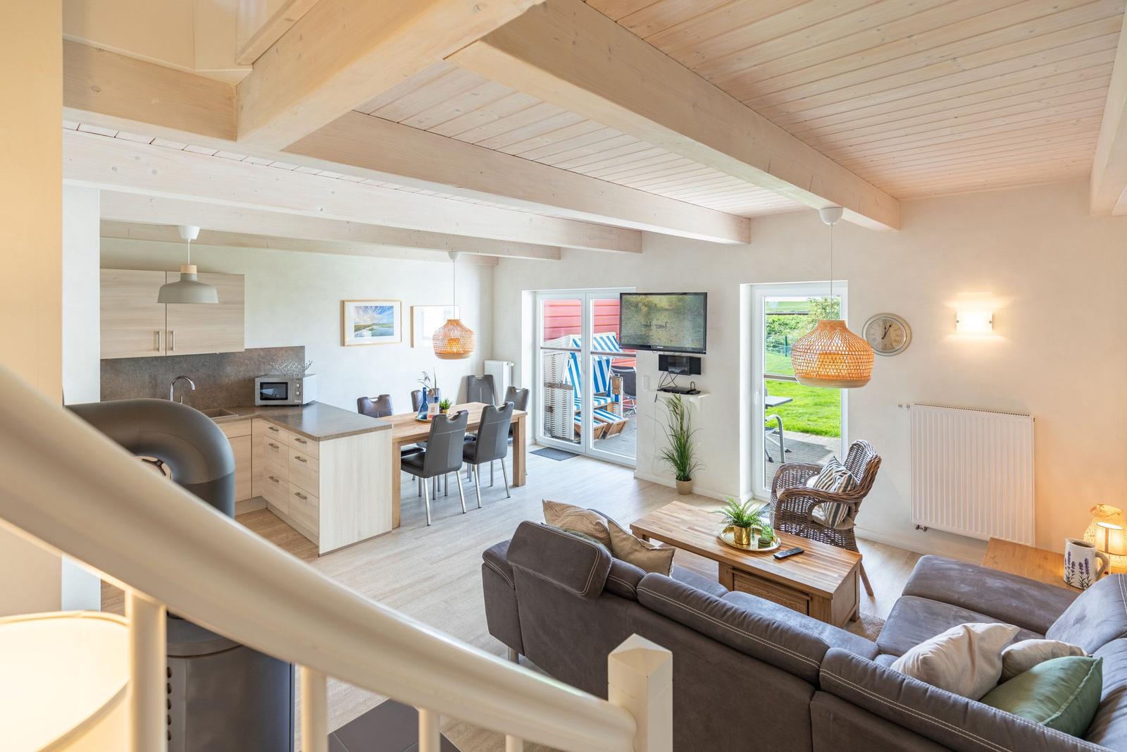 Living area with kitchen and terrace. Wooden ceiling, sofa, and dining area.