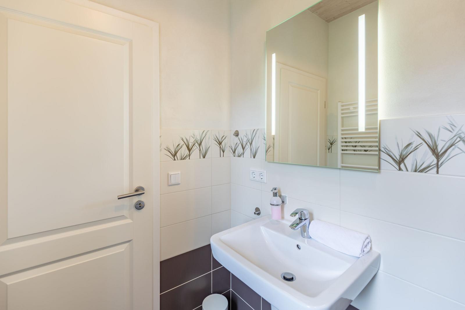 Bathroom with sink, mirror, and towel.