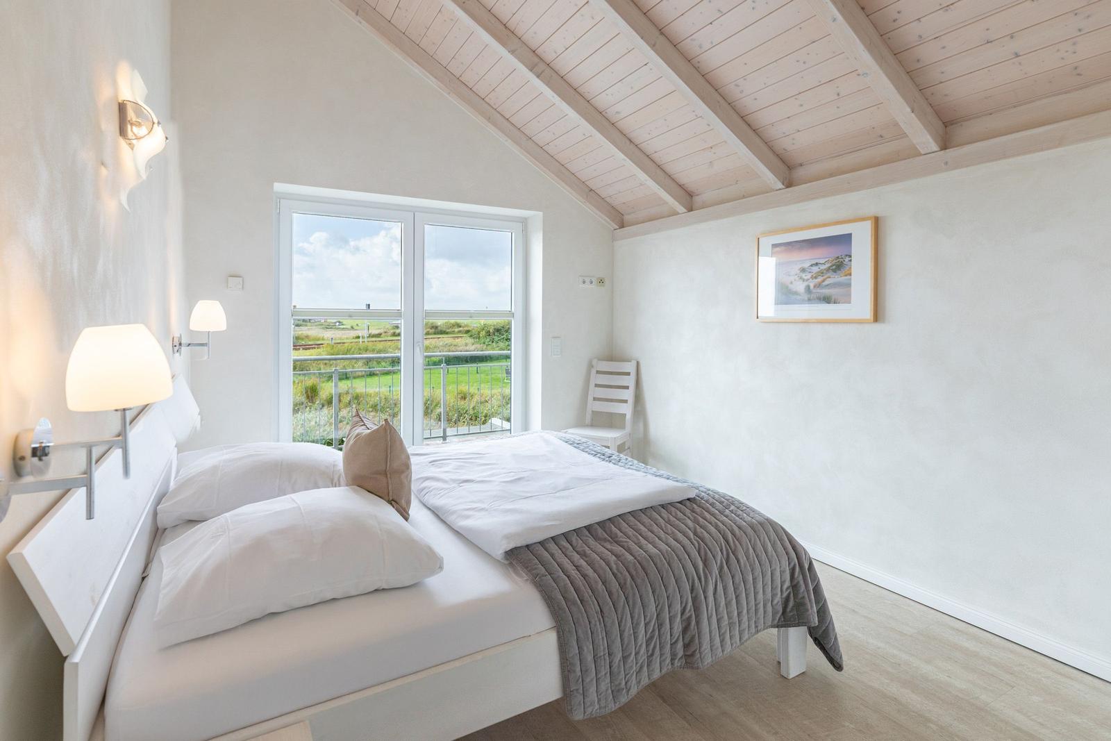Bedroom with view of the landscape through the glass door.